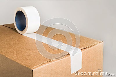 Corrugared brown cardboard box with white adhesive tape Stock Photo