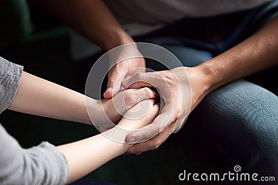 Close up of couple holding hands, giving psychological support c Stock Photo