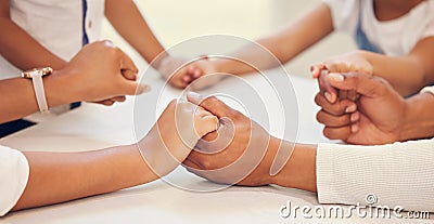 Close up of couple holding hands and praying with their kids at table. Parents and children saying prayer and worship Stock Photo