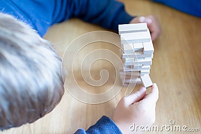 Close up couple playing jenga indoor on table.Boy lying down and playng Stock Photo