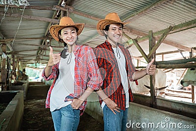 close up of a cowboy couple standing and smiling with their thumbs up Stock Photo