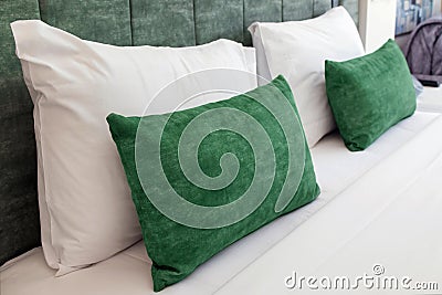 Close-up of cozy bed with light green soft pillows and headboard Stock Photo