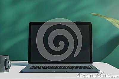 Close up of creative designer office desktop with empty laptop monitor with mock up place in frame, green wall background with Editorial Stock Photo