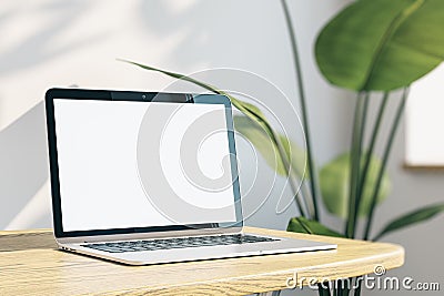 Close up of creative designer office desktop with empty white laptop monitor with mock up place in frame, concrete wall background Editorial Stock Photo