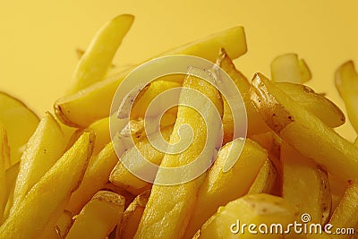 Close Up Of Crispy Golden French Fries On Yellow Background Stock Photo