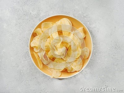 Crispy potato chips or crisps in a yellow plate Stock Photo