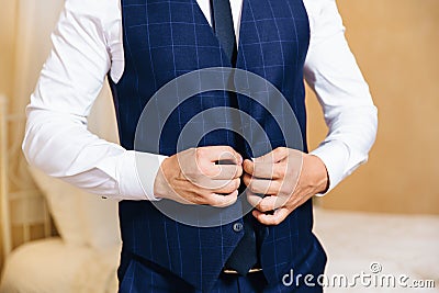 Close-up of a cropped frame of a business stylish man buttoning his jacket, standing in a stylish office with designer Stock Photo