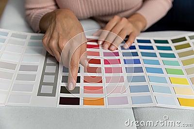 Close up cropped woman painting finger at color in catalogue Stock Photo