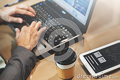 Close up cup of coffee on table. Businessman hands typing on his Stock Photo