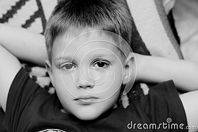 Close up of a cute young boy lying on bed Stock Photo