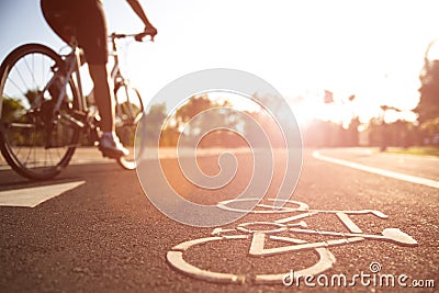 Close up cycling logo image on road with athletic women cyclist legs riding Mountain Bike in background at the morning Stock Photo