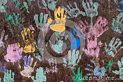 Dark background with colorful handprints symbolising interracial friendship Stock Photo