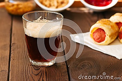 Close up of dark beer in a glass with pigs in a blanket, ketchup Stock Photo