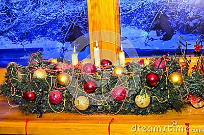 Close-up of a decorated garland from the branches of a New Year tree with Christmas decorations and lit candles. Stock Photo