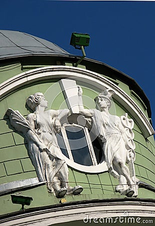 Close up decorative circle attic window with two sculptures Stock Photo