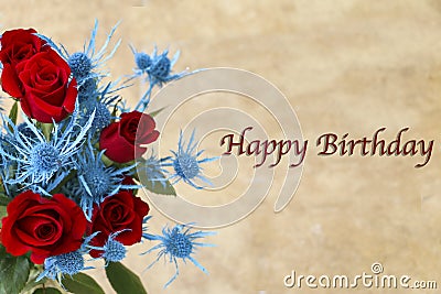 A Close-up of Deep Red Roses with Alpine Sea Holly and Happy Birthday on the Right side of the Image. Stock Photo