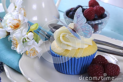 Close up of delicious cupcake with butterfly wafer decoration on vintage aqua blue tray setting Stock Photo