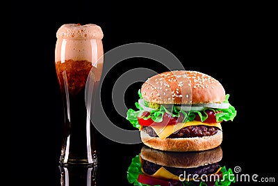 Close-up of delicious fresh home made burger with lettuce, cheese, onion, tomato and cola drink or dark beer with ice on Stock Photo