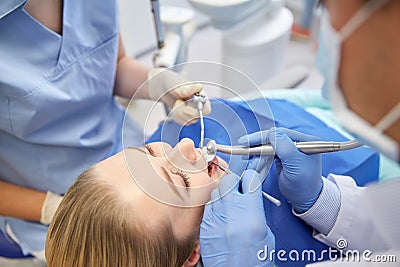 Close up of dentist treating female patient teeth Stock Photo