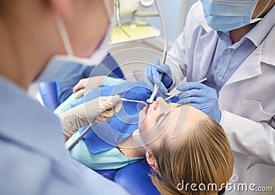 Close up of dentist treating female patient teeth Stock Photo