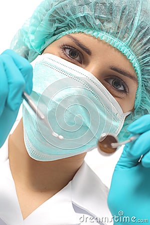 Close up of a dentist woman with a mask holding tools ready to operate Stock Photo