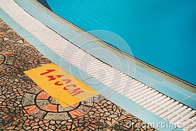 Close up Depth indicating sign with clear blue swimming pool. Stock Photo