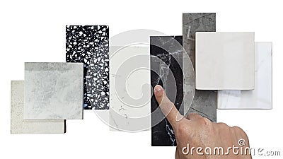 close up designer's hand picking interior premium stone samples including black marble, grey artificial stone. Stock Photo