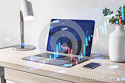 Close up of desktop workplace with laptop, other items and abstract growing forex chart on blurry background. Economy, up, growth Editorial Stock Photo