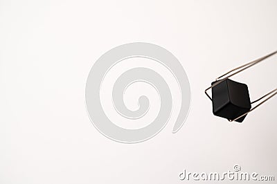 A close-up of a detached mechanical keyboard keycap hanging in a stainless steal keycap and switch puller tool on a white Stock Photo