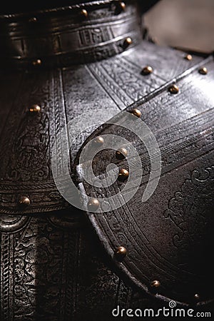 Close up detail Background with armour of the medieval knight. Metal protection of the soldier. Steel Plate. Rivets and engraving Stock Photo