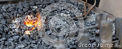 Close-up detail old medieval blacksmith furnace with hot burning coal flame forge iron metal. Craft smith farrier Stock Photo