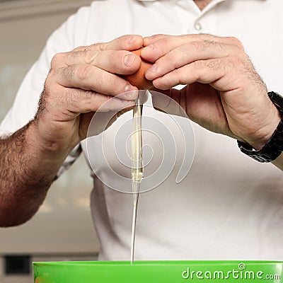 Close-up detail shot of man`s hands breaking an egg Stock Photo