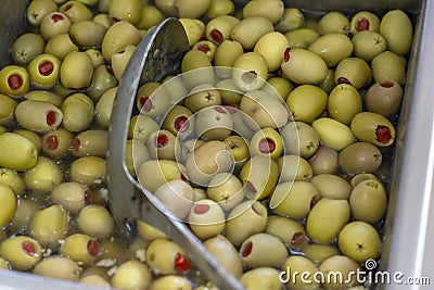 Close-up detail shot of red pepper filled green olive in metal box Stock Photo