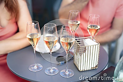 Close-up detail table with many filled glasses of white champagne prosecco at party celebration event outdoors. People having fun Stock Photo