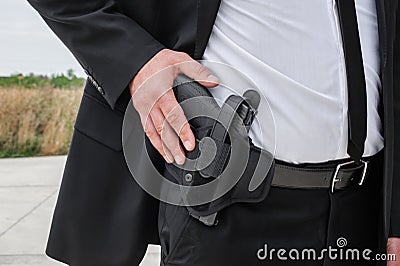 Close-up detail view of hand with gun in bandolier belt Stock Photo