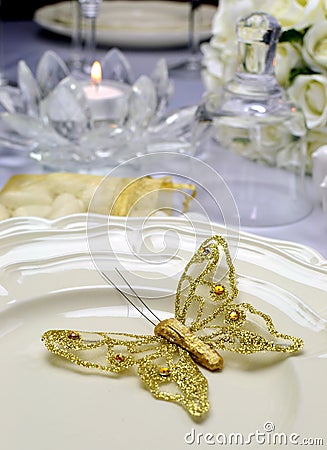 Close up of detail on wedding breakfast dining table setting with gold butterfly on china plates Stock Photo