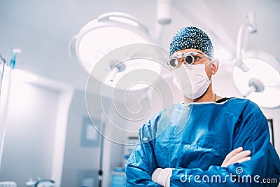 Details of man, surgeon specialist wearing goggles and scrubs ready for surgery Stock Photo