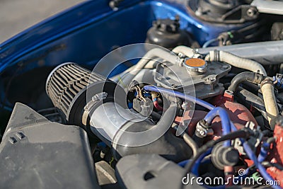 a close up details in the motor engine of a vehicle sport racer car with opened hood Stock Photo