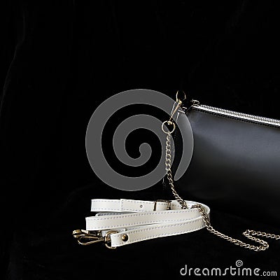 Close-up detal of leather handbag, always classic combination, black and white color with strap and chain. For modern Stock Photo