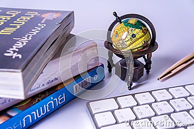 An ancient world globe, books, pen and keyboard Editorial Stock Photo