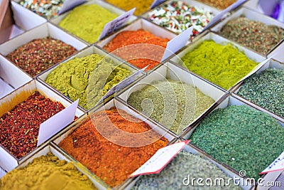 Close-up of different types of colored oriental spices and seasonings on market in square forms with price tags Stock Photo