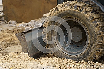 Close-up of dirty bucket teeth and excavator wheel. Stock Photo