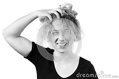 Close-up of a disheveled girl laughing holding her head and ruining her hair. B W toning. The concept of emotions of joy Stock Photo