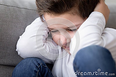 Close up of stressed child cover head suffering from conflicts Stock Photo
