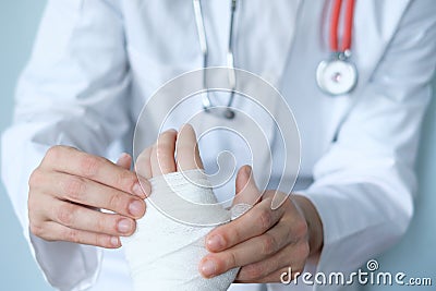 Close up of doctor bandaging one hand Stock Photo