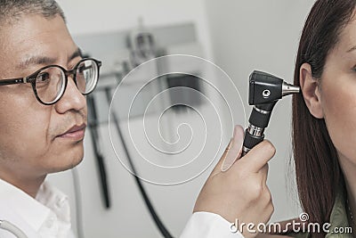 Close-Up of doctor checking the ears of a patient Stock Photo