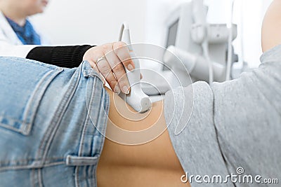 Close-up doctor conducts ultrasound diagnostics of the patients abdomen and internal organs Stock Photo