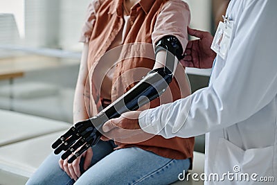 Close up of doctor fitting mechanical prosthetic arm to young woman Stock Photo