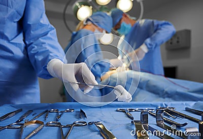 Doctors using medical instruments during plastic surgery. Stock Photo