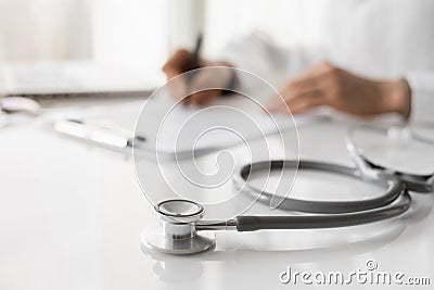 Close-up of doctor medical professional wearing uniform taking notes, physician or therapist filling medical document Stock Photo